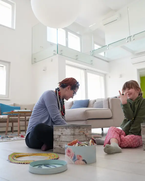 Mamma och dotter leker på golvet i vardagsrummet