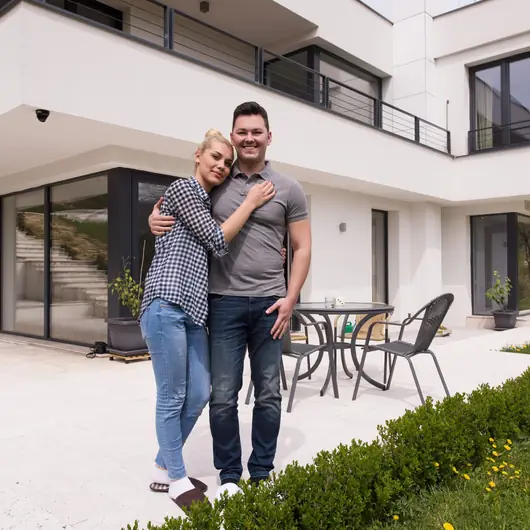 Par framför sin nybyggda villa
