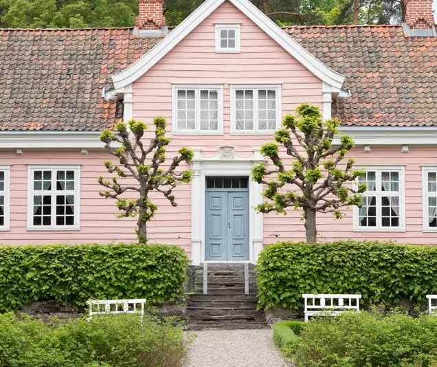 Rosa trähus med trädgård