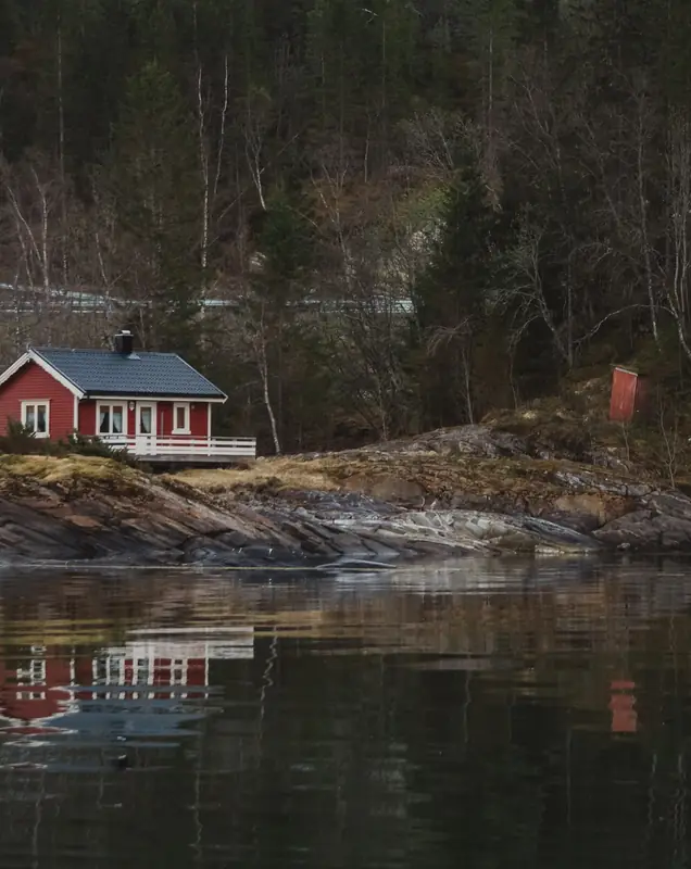 Rött trähus vid en sjö