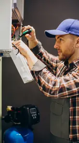 Servicetekniker justerar ett värmesystem inomhus